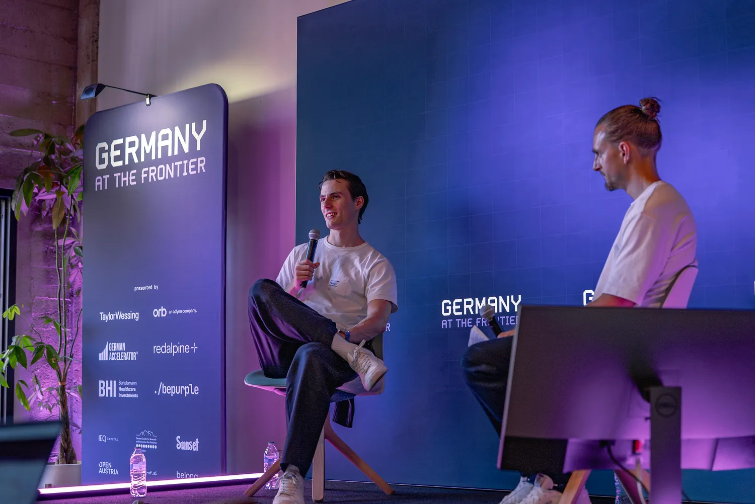 A fireside chat on the Germany at the Frontier stage, lit in purple