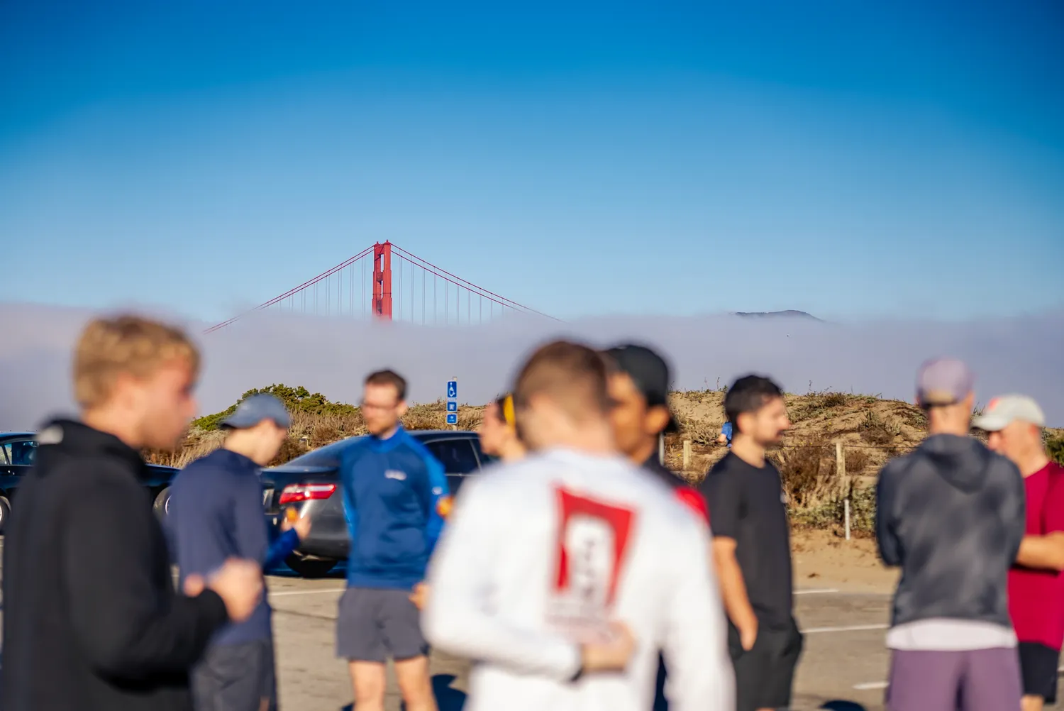 Runners with the Golden Gate Bridge in the fog behind them